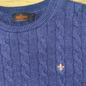 Blå kabelstickad tröja från Morris i pima Cotten - Kabelstickad blå tröja från Morris i 100% bomull. Taggen i nacken är lite skadad men annars helt defektfri. Storleken är M men sitterr som S