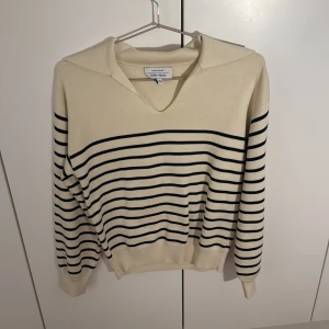 Randig tröja från & Other Stories XS - Snygg krämvit tröja från & Other Stories i storlek XS med marinblå horisontella ränder. Tröjan har v-ringning, bred krage och långa ärmar. Perfekt för en chill och stilren look. Aldrig använd, kommer ej till användning💕