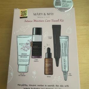 Mary & May Intense Moisture Care Kit - Resekit med fem hudvårdsprodukter från Mary & May: vegansk low pH hyaluronsyra gel cleanser i vit tub, blackberry complex cream essence i lila/svart pumpflaska, idebenone + blackberry serum i brun glasflaska med pipett och tranexamic acid + glutathione eye cream i silver tub. Medföljer en beige bomullspåse.