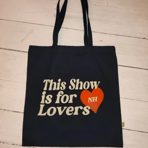 Niall Horan - This Show is for Lovers tote bag - Niall Horan marinblå tote bag. 'This Show is for Lovers' i vitt och ett rött hjärta med NH-logga. Köpt på hans konsert i Stockholm 2024! Säljer då jag bara använt den några få gånger. OBS! det är två fläckar som inte går bort på hjärtat (se bild 2)