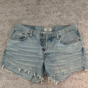 Jeans shorts - Ett par väl använda jeans shorts från märket Crocker. Waist 34 och length 34. Fina knappar i fram Dock finns det en fläck på ena fickan som jag inte vet om man kan ta bort men därav priset. Hör av dig vid frågor och priset går att diskuteras💕