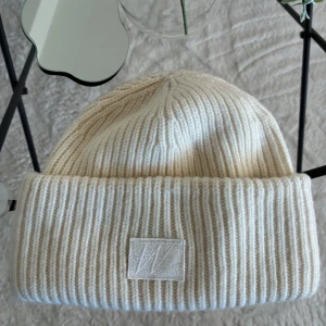 Vit ribbstickad mössa Carin Wester - Snygg vit ribbstickad mössa från Carin Wester, modell Edith.