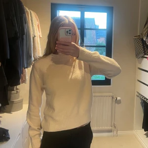 Beige stickad tröja från Mango - Supermjuk beige stickad tröja från Mango med klassisk rund hals och långa ärmar. Tröjan har en enkel och clean look med ribbade muddar vid ärmslut och nederkant. Den är i storlek S och passar perfekt i vinter men även en kall sommarkväll!! Den är ljust rosa/peach skulle jag beskriva den!