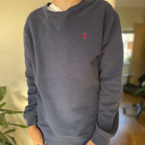 Mörkblå sweatshirt från Polo Ralph Lauren - Den simpla marinblåa Ralph lauren tröjan. Använd hyfsat mycket men inga synliga defekter. Skick 7/10 den skulle väll passa någon runt 175-180 cm skulle jag tro.