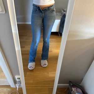 Blå bootcut jeans låg midja - Säljer ett par klassiska blå jeans med låg midja. Har spretat upp dom i längden för att få dom nån centimeter längre. Superfina byxor men tyvärr har de blivit för små.💕💕