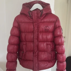 Röd vinterjacka  - Super snygg och skön vinterjacka från superdry xp-d+. endast använd en vinter så inga defekter. Kommer ej till användning då jag köpte en ny jacka detta året så hoppas någon annan vill köpa🥰🥰