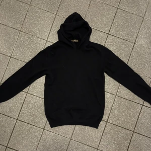 Mörkblå tröja i kashmir från Oscar Jacobson - Mörkblå tröja från Oscar Jacobson i mjuk kashmir. Klassisk design med huva och långa ärmar, perfekt för dig som gillar stilrena och bekväma plagg. Passar dig som vill ha en enkel men lyxig tröja med skön känsla. Storlek M men den är liten i storleken. Det finns lite noppror som är enkla att ta bort med en noppborttagare