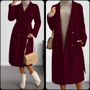 NY Vinröd kappa med bälte och knappar - Snygg vinröd kappa med dubbelknäppning och bälte i midjan. Lång modell med klassisk krage och raka ärmar. Kappan har silvriga knappar och en stilren look som passar perfekt till höst och vinter. Materialet ser ut att vara ull eller polyester.