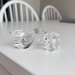 Glasfigurer - fågel och elefant - Två dekorativa glasfigurer, en fågel och en elefant, i klart glas med fina detaljer. Perfekt som prydnad eller samlarobjekt. Båda figurerna är i mycket gott skick utan synliga skador eller slitage.