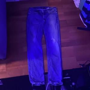 Blå jeans från Jack & Jones Regular/Clark - Snygga blå jeans från Jack & Jones i modellen Regular/Clark. Klassisk femficksdesign med knapp och dragkedja i midjan. Jeansen har en rak passform och är tillverkade i slitstarkt denimtyg. Perfekt för dig som gillar en enkel och tidlös stil.