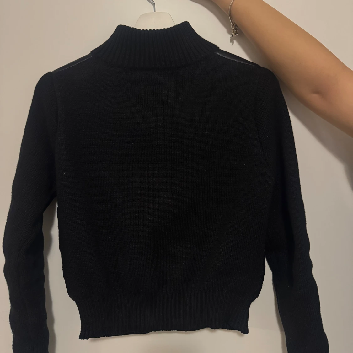 Svart pufferjacka med stickade ärmar - 1