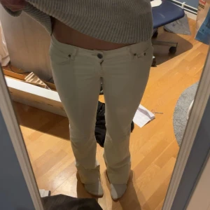 Vita bootcut jeans - Snygga vita jeans med bootcut passform och låg midja. Klassisk femficksmodell med knapp och dragkedja framtill. Perfekta för dig som vill ha en clean och fräsch look.