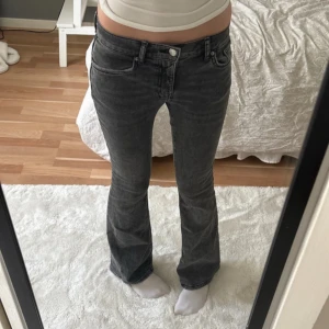 Lågmidjade jeans  - Snygga mörkgråa jeans från Gina Tricot med bootcut passform och låg midja. 