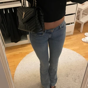 Blå bootcut jeans med låg midja - Snygga blå jeans med bootcut passform och låg midja. 