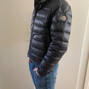 Svart Moncler pufferjacka herr - Snygg svart pufferjacka från Moncler. Perfekt nu inför höstens sista dagar. Storlek 2 (S) ( små i storlekarna) Skick 9/10  modell: Acorus. Jackan har quiltad design,  Perfekt för dig som vill ha en stilren höst/vår jacka 