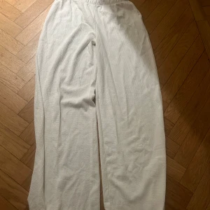 Vita linnebyxor från 15 S - Säljer ett par vita linnebyxor från 15 S i storlek S. Byxorna har en avslappnad passform med resår i midjan och är tillverkade i ett strukturerat linnematerial. Perfekta för en chill och stilren look under varma dagar.