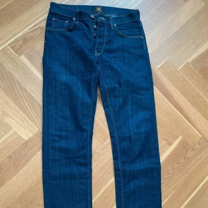 Mörkblå jeans från Lee straight fit 29/32 - Snygga mörkblå jeans från Lee med klassisk straight fit och fem fickor. Jeansen har kontrastsömmar, knappgylf och Lee-läderpatch baktill. Perfekt för dig som gillar tidlös stil och vill ha ett par jeans som funkar till allt. 29/32 mycket fint skick 