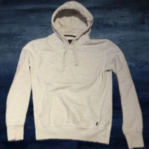 Ljusgrå Superdry hoodie  - En unik grå superdry hoodie i storlek M i bra skick!