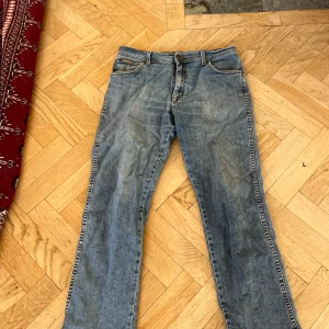 Wrangler Texas Stretch jeans blå W34 L30 - Blå Wrangler Texas Stretch jeans med klassisk femficksdesign och snygga kontrastsömmar. Modellen har rak passform och normal midja, tillverkad i stretchigt denim för extra komfort. Perfekt för dig som gillar en tidlös och avslappnad stil.