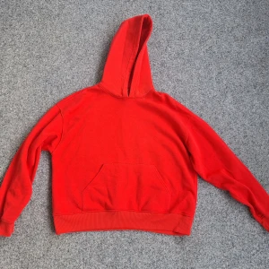 Röd hoodie från Gina Tricot - Säljer en röd hoodie från Gina Tricot, basically basics-kollektionen. Tröjan har en stor huva, magficka och ribbade muddar vid ärmslut och nederkant. Perfekt för chill dagar och enkel att matcha med jeans eller mjukisbyxor.