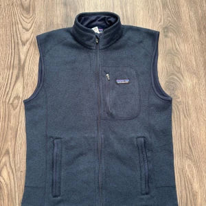 Mörkblå Patagonia fleeceväst   - Snygg mörkblå/navy fleeceväst från Patagonia i storlek M herr/unisex. Perfekt för hösten och perfekt lager-på-lager plagg.                                              260 + nöjda kunder på Vinted (a_ad) fraktas inom 24 timmar. Mått: längd:66 cm bröst: 52 axelbredd: 46 cm 