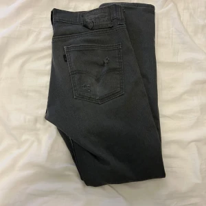 Levi's 511 mörkgrå jeans - Snygga mörkgrå Levi's 511. Jeansen har slitningar på baksidan av varje fixj och lite på högerfickan, dom sitter lite slim, pris kan diskuteras vid snabb affär