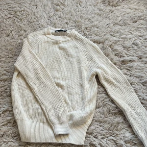 Vit stickad tröja från 157 XS - Säljer en vit stickad tröja från 157 i storlek XS. Tröjan har grovstickad struktur, rund hals och ribbade muddar vid ärmslut och nederkant. Perfekt för dig som gillar enkel och clean stil med lite oversized känsla.