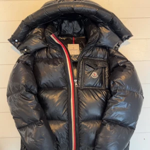 MONCLER Montbeliard - Säljer en Moncler ”Montbeliard” jacka. Storleken är 2 vilket motsvarar storlek M. Jackan har en del lagningar därav priset. Lagningarna är dock svarta och smälter därför väldigt bra in med jackan. Först till kvarn!🙌🏻