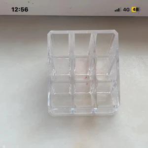 Läppstift Nabla & Läppglans Smashbox - Säljer ett svart och guldigt läppstift från Nabla och ett nude-rosa läppglans från Smashbox. Båda kommer i en genomskinlig akryl sminkförvaring med flera fack, perfekt för att organisera dina favoritprodukter på sminkbordet.