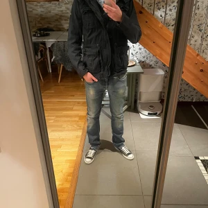 Replay jennon jeans blå straight fit - Säljer ett par Replay jennon jeans i snyggt tvättad blå färg med slitningar och klassiska fem fickor. Modellen har rak passform och normal midja, med Replay-logga på knappen. Perfekt för dig som gillar en avslappnad men stilren look.