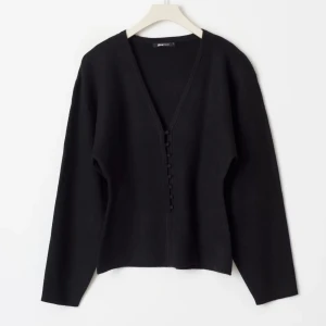 Shaped knitted cardigan från Gina Tricot - Stilren svart kofta från Gina Tricot med djup v-ringning och knappar framtill. Långärmad och i mjukt stickat material. Enkel att matcha med allt i garderoben. Ny pris 399kr. 