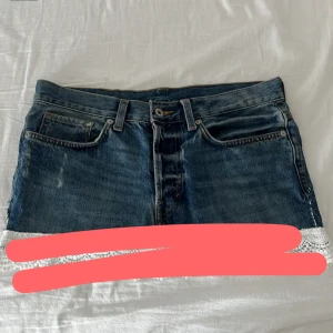 Jeanskjol  från &Denim - Snygg blå jeanskjol från &Denim med klassiska fickor fram och bak, knäppning med knappar och bälteshällor. Kjolen har en kort modell. Perfekt för dig som gillar denim med en twist.