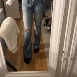 Bootcut ljusblå jeans med slitningar - Säljer mina fina Nelly jeans då dom inte kommer till användning! 💞