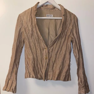 Beige kavaj från Gerard Darel - Säljer en beige kavaj från Gerard Darel med snyggt skrynkligt tyg och två knappar framtill 💌i gott skick! 