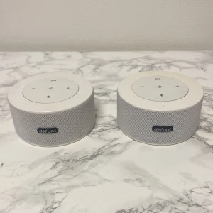Defunc Bluetooth-högtalare - Snygga vita Defunc Bluetooth-högtalare med tydliga knappar för volym, power och Bluetooth. Utrustade med AUX-ingång och micro-USB-laddning. Bra skick, endast mindre yttre slitage synligt. Perfekt för musik hemma eller på språng.