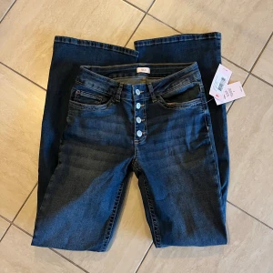 Utsvängda mid waist jeans - Helt oanvända jeans från Nelly i mörkblå färg. Stretchigt material! Nypris 699kr