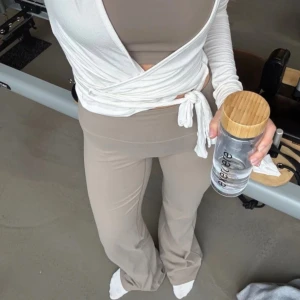 Exercere Beiga utsvängda S tall long length yogabyxor träningsbyxor thights - Supersnygga beiga yogabyxor från Exercere med hög midja och bootcut/vida ben. Byxorna är stretchiga och sitter tajt upptill med utsvängda ben. Helt oanvända i mycket bra skick. Färgen är sand beige. Normala i storleken. Storlek S, längd ”long length”. Innerbenslängden är 88cm. Mjukt material, stretch och squat proof. Tillverkade i mjukt och följsamt material. 