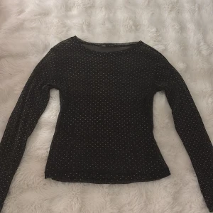 Svart glittrig mesh topp från Zara - Svart långärmad mesh topp från Zara med glittriga detaljer och prickigt mönster. Tunn och lätt transparent, perfekt för att addera lite extra till din outfit. Rund halsringning och slim passform som sitter snyggt på kroppen. Pris kan diskuteras💗