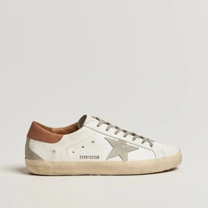 Golden Goose vita sneakers med stjärna - Golden Goose sneakers i vitt skinn med grå mockadetaljer och ikonisk stjärna på sidan. Skon har grå snörning, beige mocka på häl och tå samt en vintage-inspirerad sula. Perfekt för dig som gillar en avslappnad men trendig look.