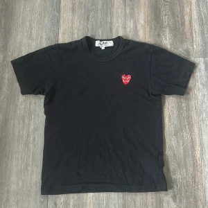 Svart t-shirt från Comme des Garçons Play - Svart t-shirt från Comme des Garçons Play med det ikoniska röda hjärta-märket broderat på bröstet🤩Klassisk rund halsringning och korta ärmar. Perfekt för en stilren och trendig look.🔥