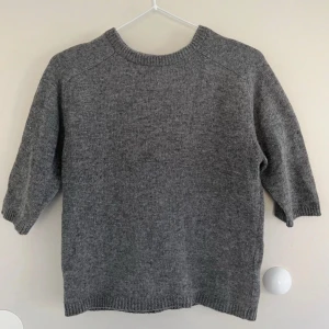 Grå stickad tröja från Zara - Grå stickad tröja med kort ärm från Zara i jättefint skick, stl S. Den är 51cm lång mätt från axeln.