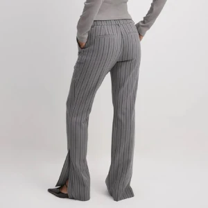 Grå kostymbyxor med ränder - Snygga grå kostymbyxor med vertikala ränder och klassisk passform. Byxorna har hällor för bälte, två bakfickor och raka ben med slits. Perfekta för en stilren look och passar till skjorta eller t-shirt.