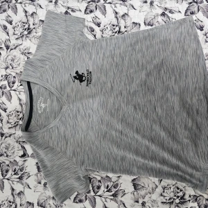 Grå v-ringad t-shirt Beverly Hills Polo Club - Snygg gråmelerad t-shirt från Beverly Hills Polo Club med v-ringning och korta ärmar. .