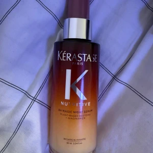 Kérastase Nutritive 8H Magic Night Serum - Kérastase Nutritive 8H Magic Night Serum med växtbaserade proteiner och niacinamid. Flaskan är 90 ml och har en snygg ombre-design i brunt och orange med silvrig pump. Perfekt för dig som vill boosta håret med extra näring under natten.
