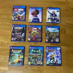 PlayStation 4 Spelpaket (9 spel) - Paket med 9 PS4-spel: LEGO Marvel Super Heroes, FIFA 22, FIFA 23, Call of Duty, Marvel Super Heroes 2, Far Cry 5, Rayman Legends, Minecraft Story Mode och Ratchet & Clank. Skivorna och fodralen ser ut att vara i gott skick, perfekta för både barn och vuxna.