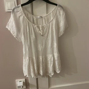 Vit blus med broderade detaljer - Säljer en söt vit blus, Perfekt för sommarens alla tillfällen! Den ska sitta ofshoulder men de va svårt att visa 