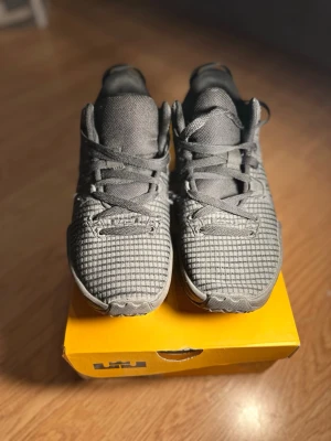 Nike LeBron Witness 7 svarta sneakers - Nike LeBron Witness 7 sneakers i helsvart mesh med coolt rutmönster och robust sula. Skorna har klassisk snörning, LeBron-logga på hälen och en sportig vibe. Perfekta för dig som gillar basketstil och vill sticka ut med snygga detaljer.