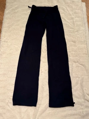 Mörkblå mjukisbyxor med dragsko - Ett par mörkblå mjukisbyxor med raka ben och dragsko i midjan. Byxorna har en enkel och clean look, perfekta för chill dagar. Tillverkade i mjukt material som känns skönt mot huden. Dragsko vid fot gör att man kan göra byxorna smalare vid benslut om man vill. 