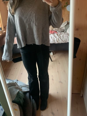 Grå ribbad långärmad tröja - Säljer en grå ribbad långärmad tröja med avslappnad passform och rund hals. Tröjan har ett enkelt och stilrent utseende, perfekt för dig som gillar en chill och basic look. Materialet känns mjukt och bekvämt mot huden. Tröjan är från bik bok. 