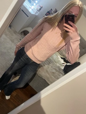 Ljusrosa stickad tröja  - Säljer en ljusrosa stickad tröja med snygg struktur och rund hals. Tröjan har långa ärmar och ribbade muddar vid ärmslut och nederkant. Perfekt för dig som gillar en enkel men söt stil.